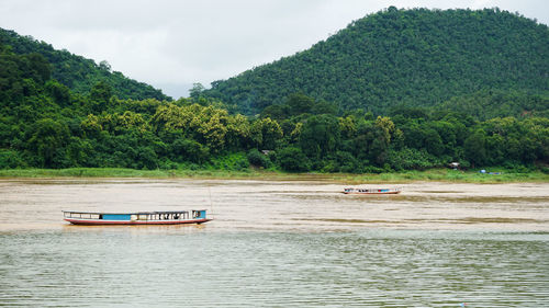 Boat in river against trees