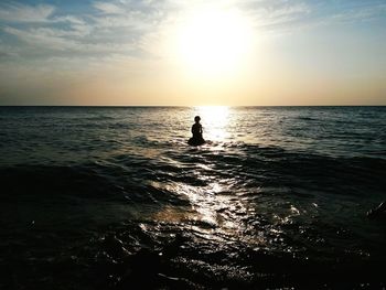 Silhouette person on beach against sky during sunset