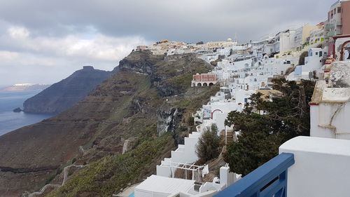 High angle view of buildings by mountain against sky