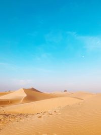 Sand dune in desert against blue sky