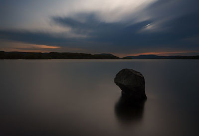 Scenic view of lake against sky at sunset