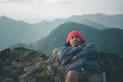 Man standing on rock against mountain range