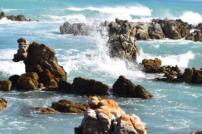 Scenic view of rocks in sea against sky