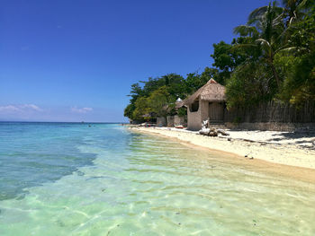 Scenic view of beach against blue sky