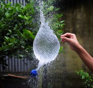 Person holding water splashing in fountain