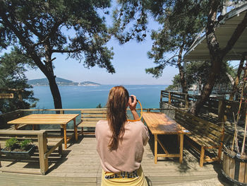 Rear view of woman sitting on chair at table