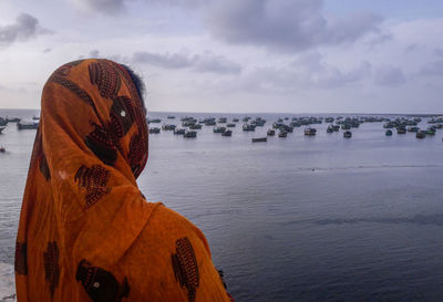 Rear view of woman looking at sea against sky