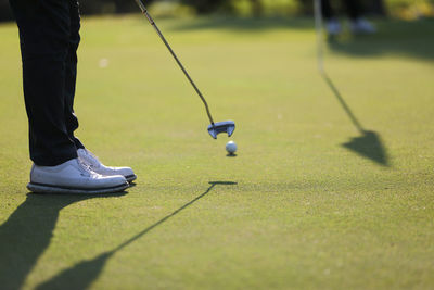 Low section of man standing on golf course