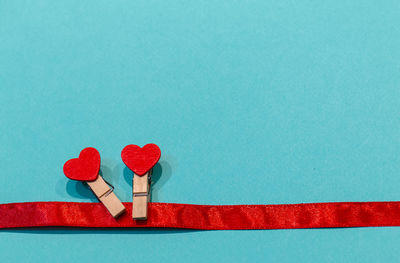 Close-up of red heart shape on table against blue background