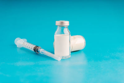 Close-up of bottle on table against blue background