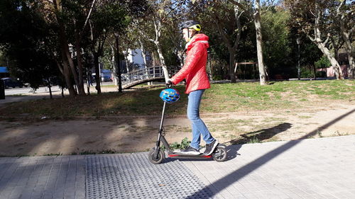 Woman riding bicycle on footpath