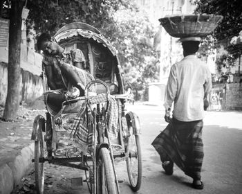 Rear view of man riding motorcycle on street in city