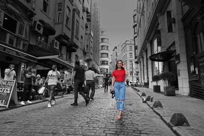 People walking on street amidst buildings in city