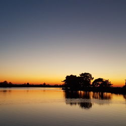 Scenic view of silhouette trees against clear sky during sunset