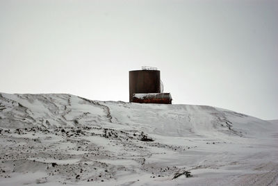 Built structure on snow covered land against clear sky