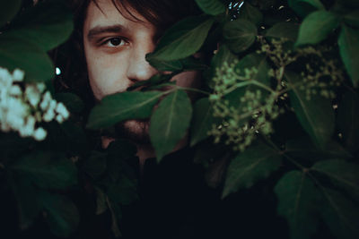 Close-up portrait of young woman with leaves