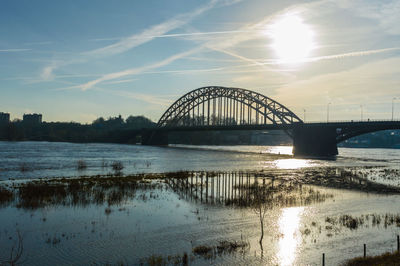 Bridge over river against sky during sunset