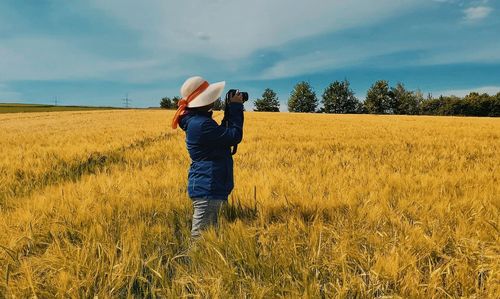 Woman photographing on field