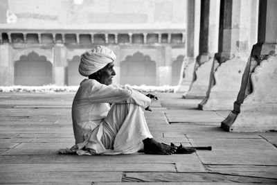 Full length of man sitting on cross