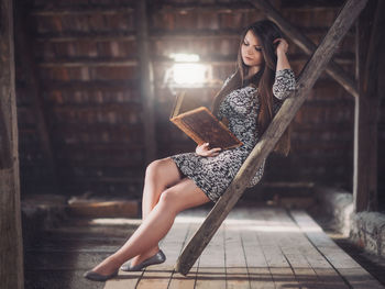 Young woman sitting reading book