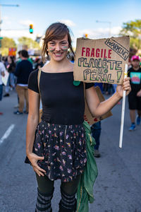 Portrait of smiling woman standing on street in city