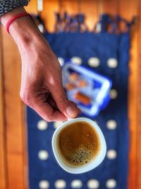 Midsection of woman holding coffee on table