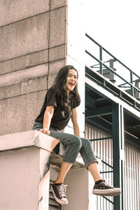 Portrait of smiling young woman on staircase