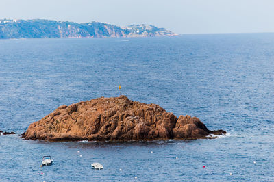 Rock formations by sea against sky