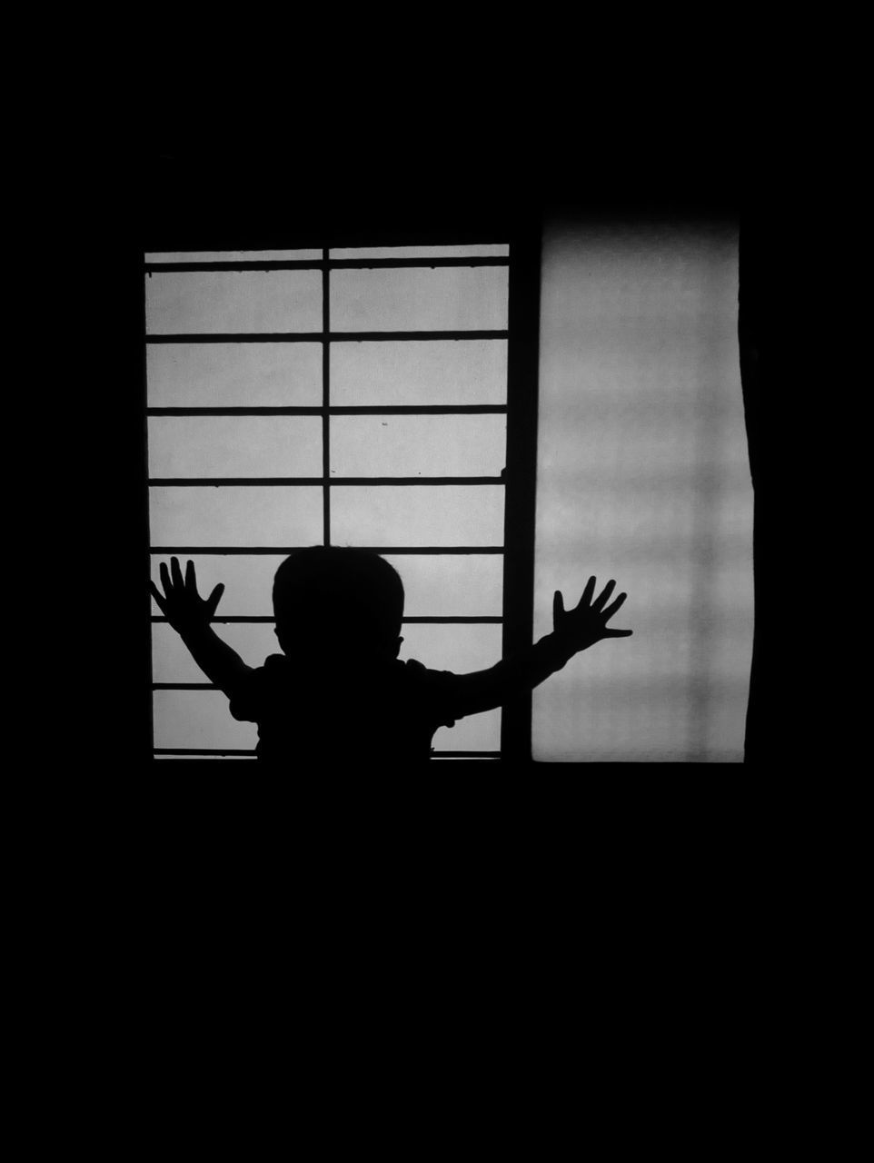 SILHOUETTE MAN STANDING BY WINDOW