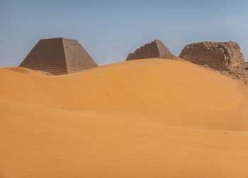Pyramids behind a large sand dune in the desert of sudan