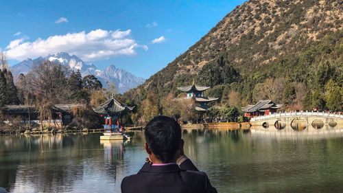 Rear view of woman looking at mountains against sky