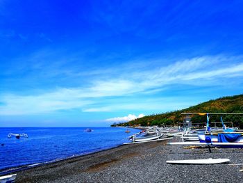 Boats moored in calm blue sea against sky