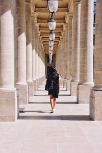 Rear view of woman walking in corridor of building