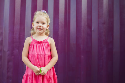 Portrait of girl standing against red curtain