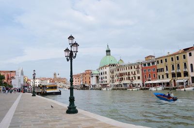 Boats in city against sky