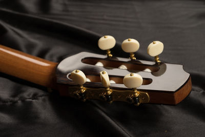 Cropped image of acoustic guitar on bed