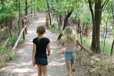 Rear view of women walking on footpath