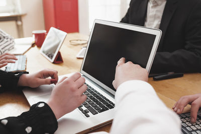 Midsection of man using laptop on table