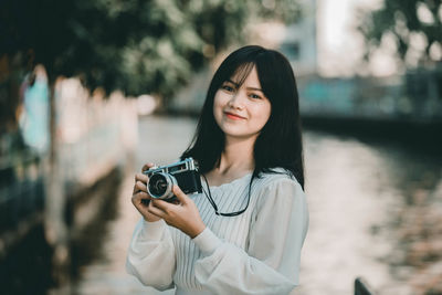 Portrait of young woman photographing