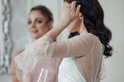 Bridesmaid and bride holding champagne flute