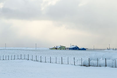 Scenic view of snow covered field against sky