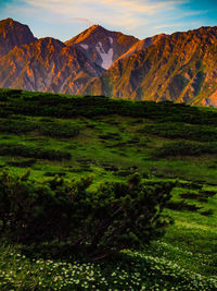 Scenic view of mountain range against cloudy sky