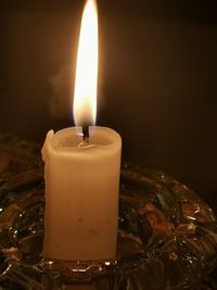 Close-up of lit candle in the dark