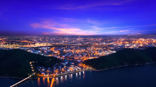 Aerial view of illuminated cityscape against sky at night