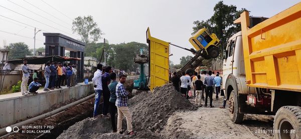 People on street in city against sky