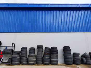 View of tires stacked by wall outdoors
