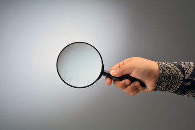 Midsection of person holding glass against white background