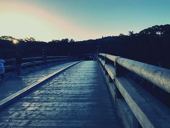 Empty railway bridge against clear sky at sunset