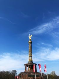 Low angle view of siegessäule in berlin against cloudy sky