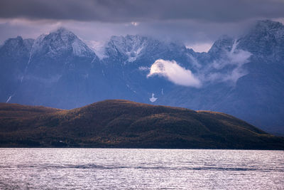 Scenic view of sea and mountains against sky